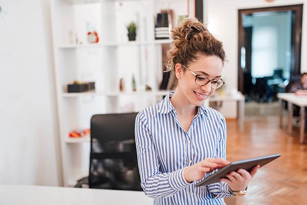 Smiling businesswoman using digital tablet.